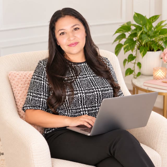 Carla sentada en un sillón con su computadora